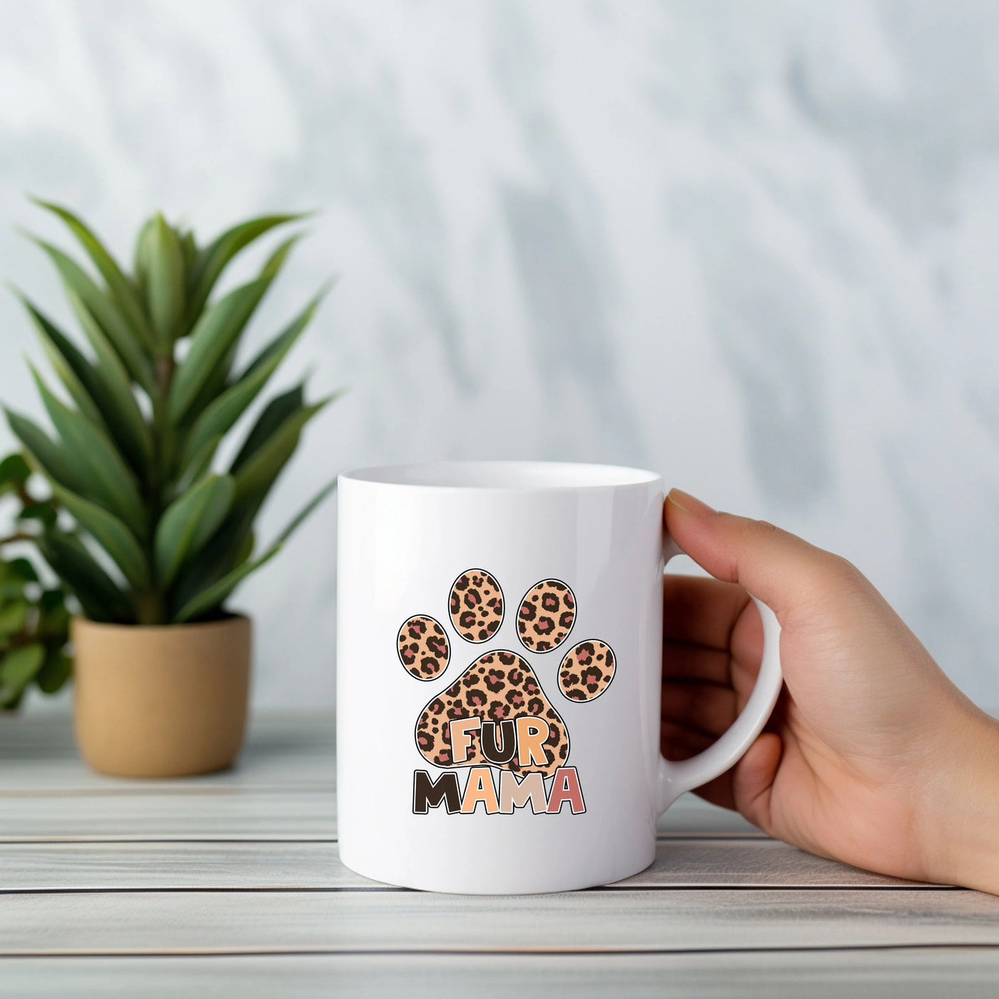 a person holding a coffee mug with a paw on it