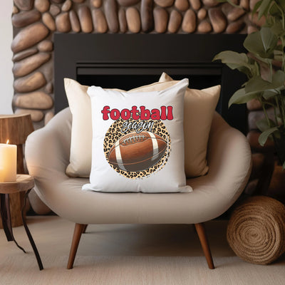 a football pillow sitting on a chair in front of a fireplace