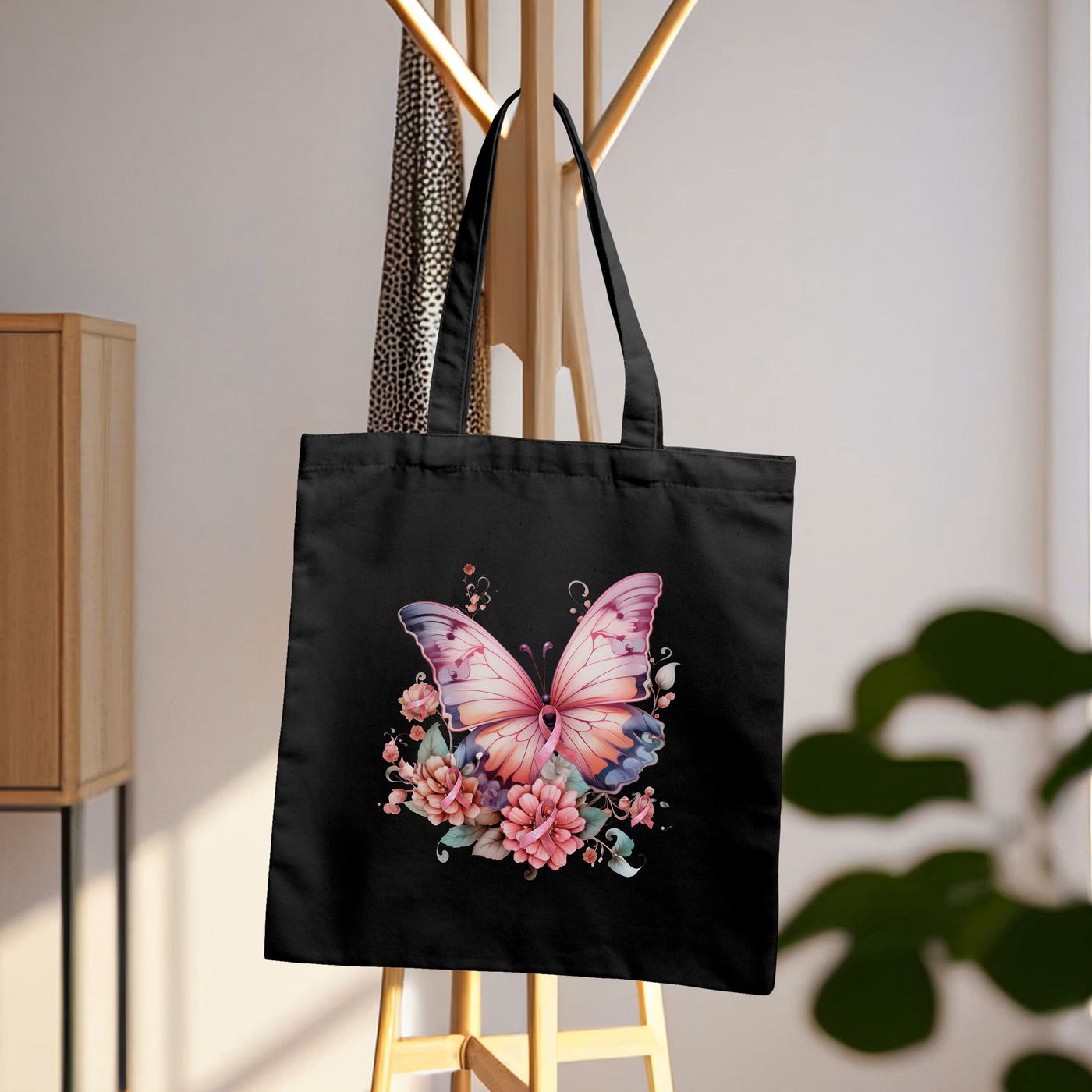 a black tote bag with a pink butterfly on it