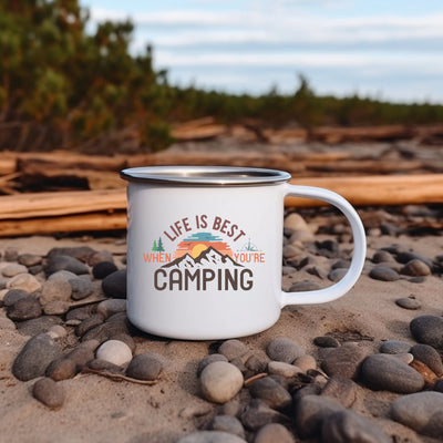 a white camp mug sitting on top of a pile of rocks