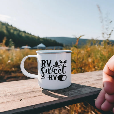 a hand holding a white coffee mug sitting on top of a wooden table