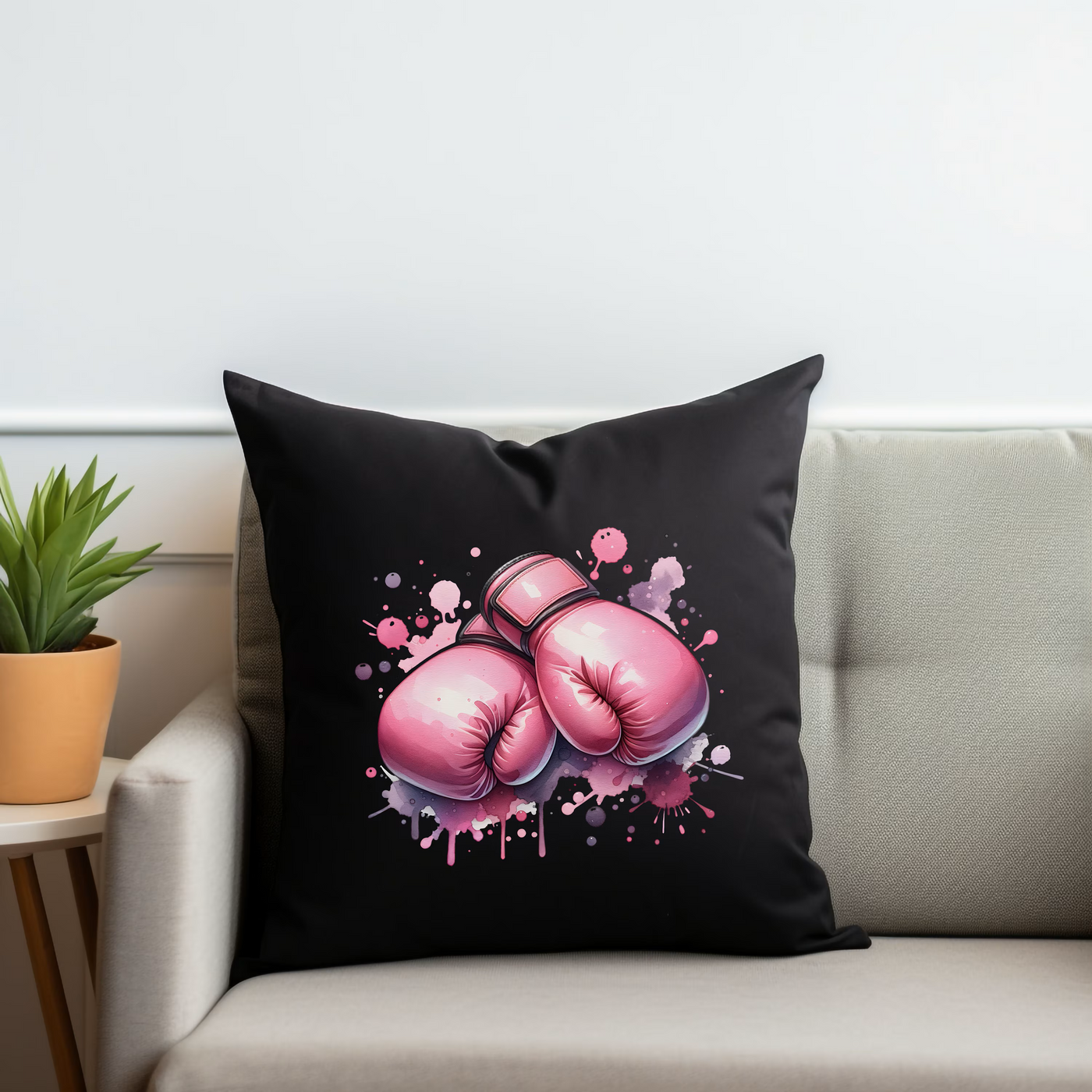 a black pillow with pink boxing gloves on it