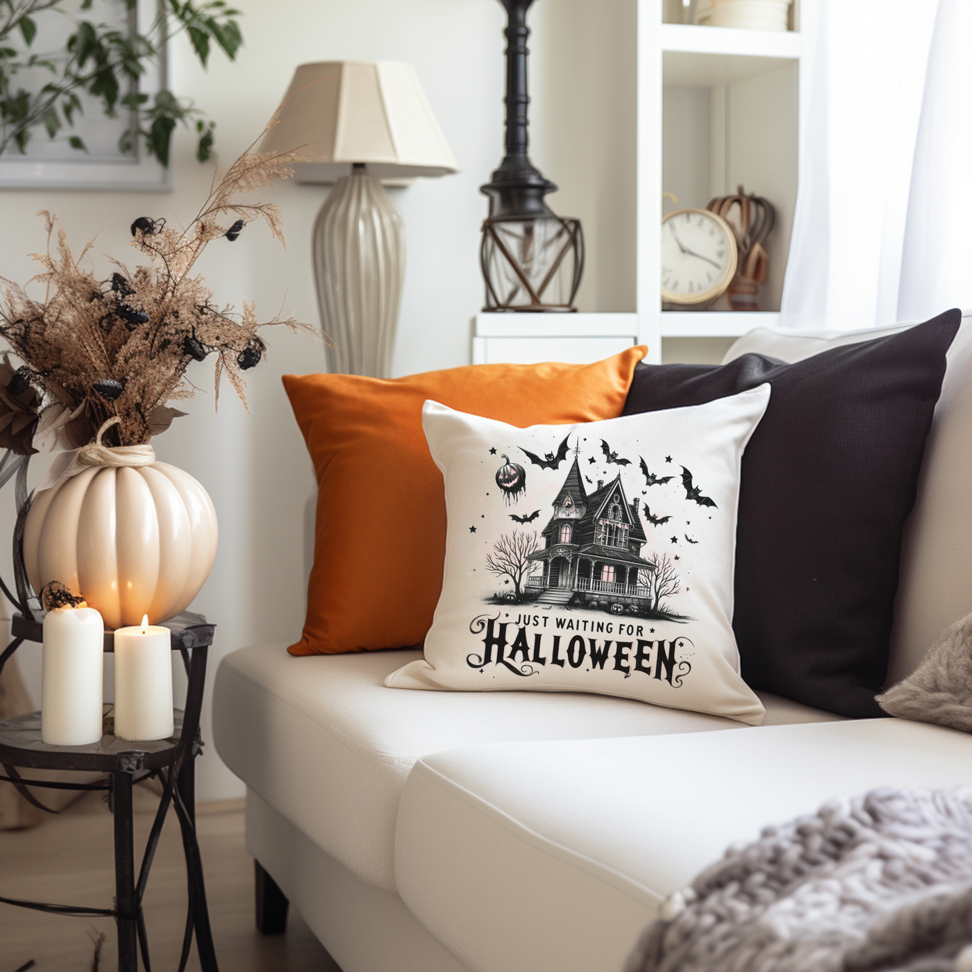 a living room with a white couch and a halloween pillow