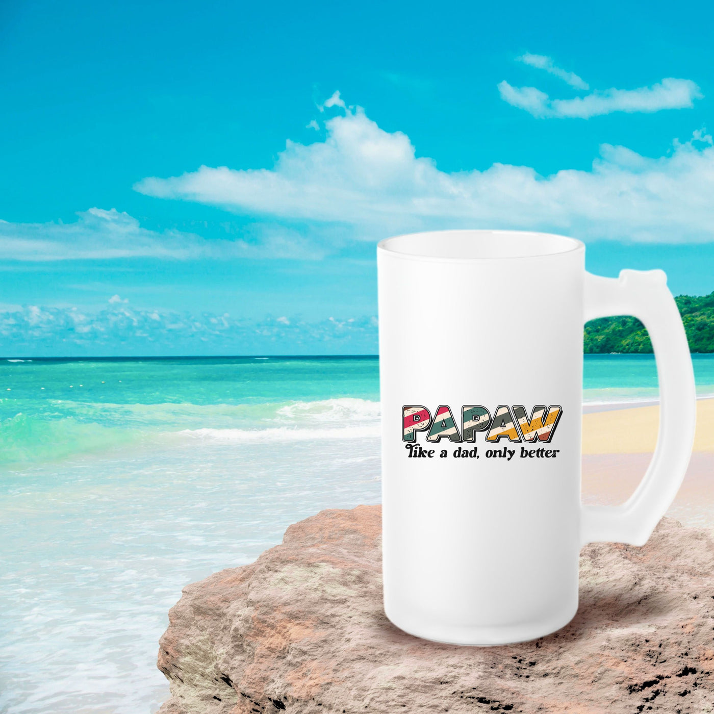 a white coffee mug sitting on top of a sandy beach