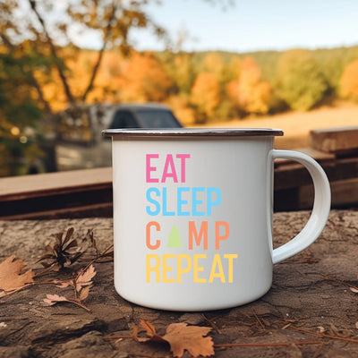 a camp mug sitting on the ground with leaves around it