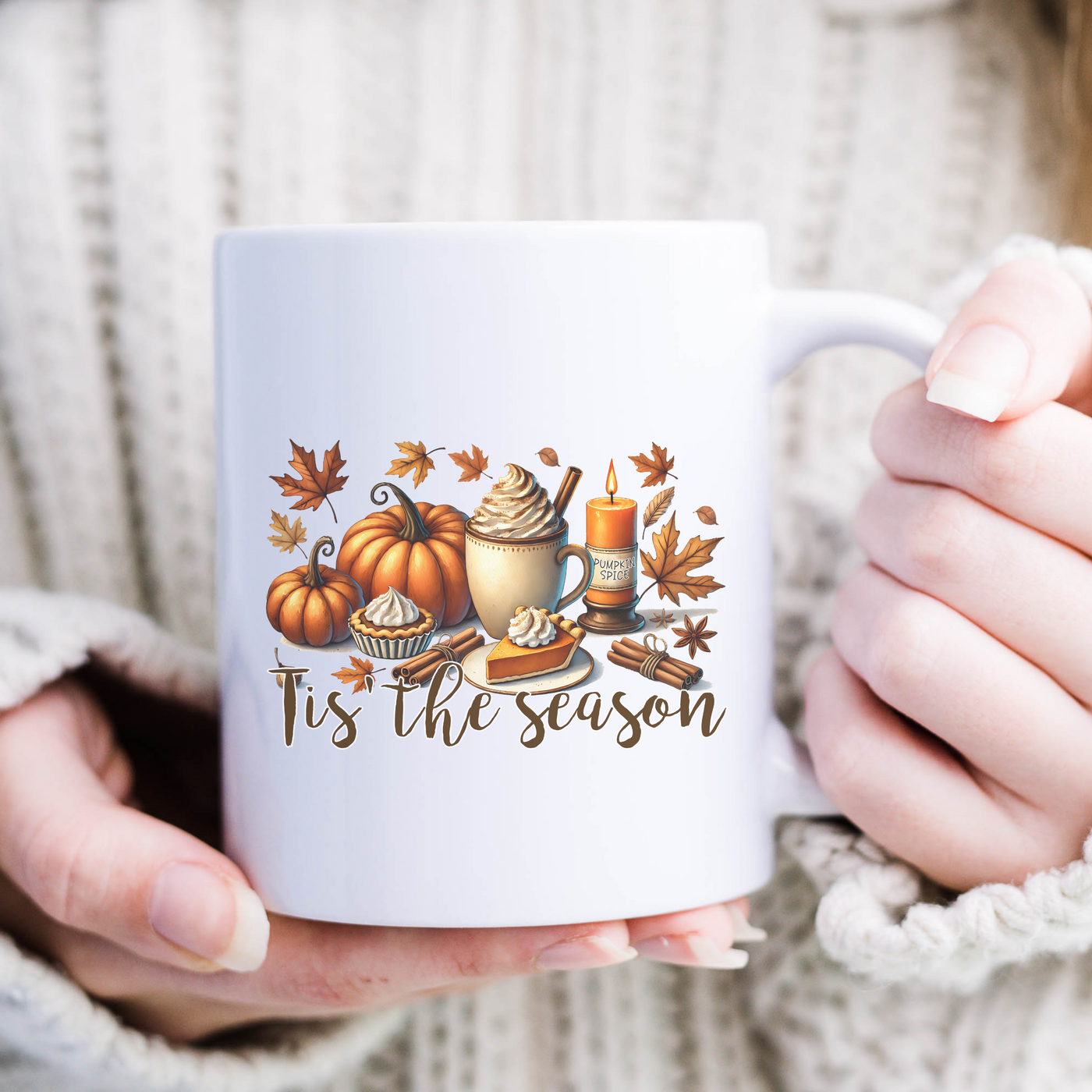 a woman holding a coffee mug with a fall scene on it