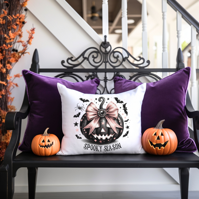 a bench with two pumpkins and a pillow on it