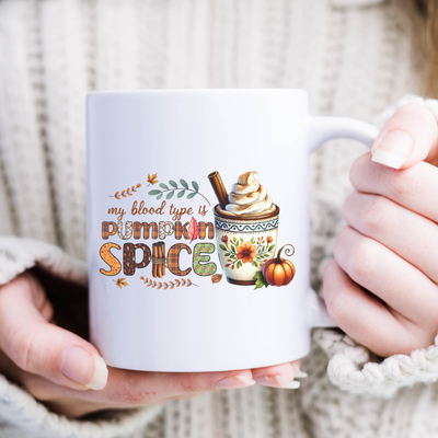 a woman holding a coffee mug with a cinnamon spice design on it