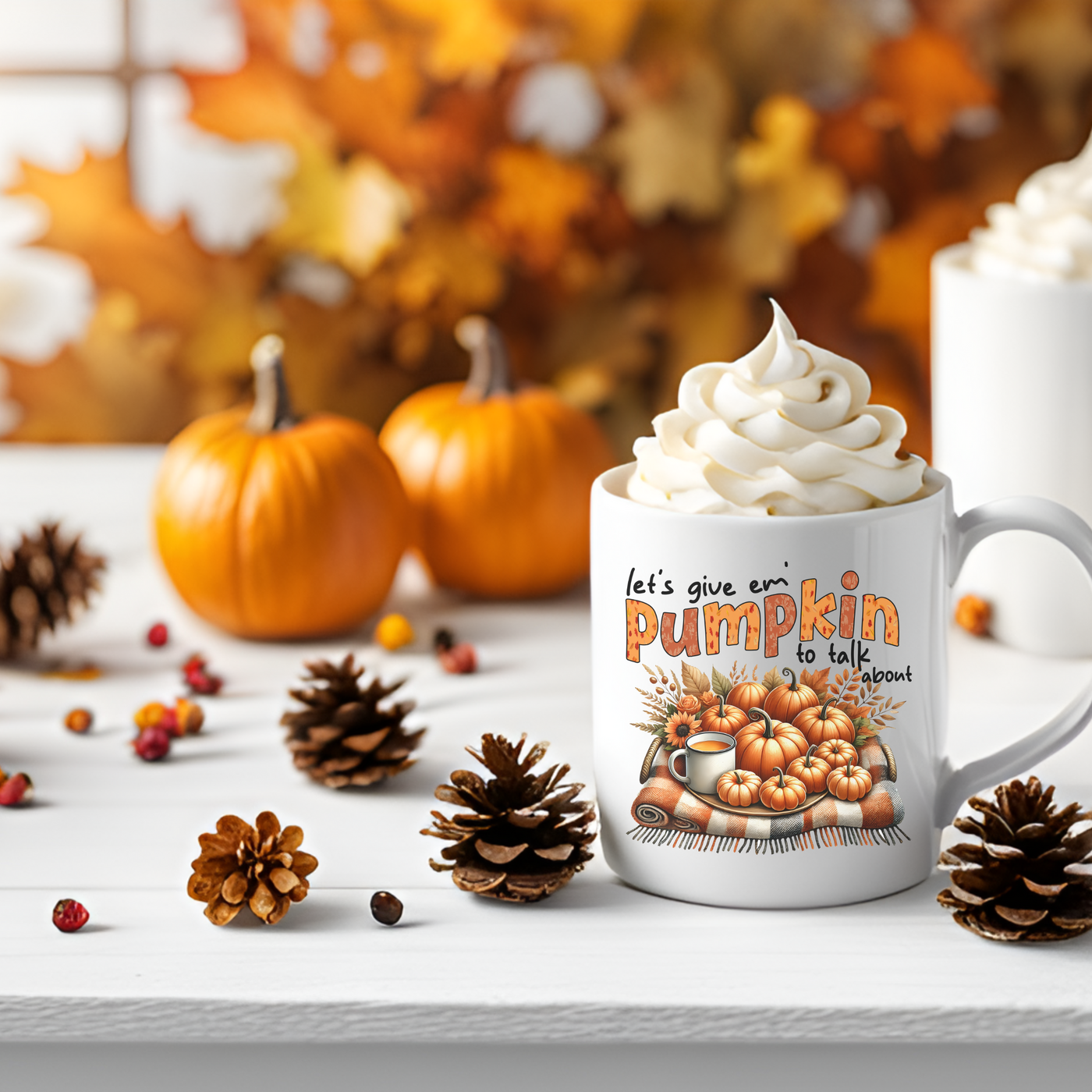 a cup of coffee with whipped cream and pumpkins around it