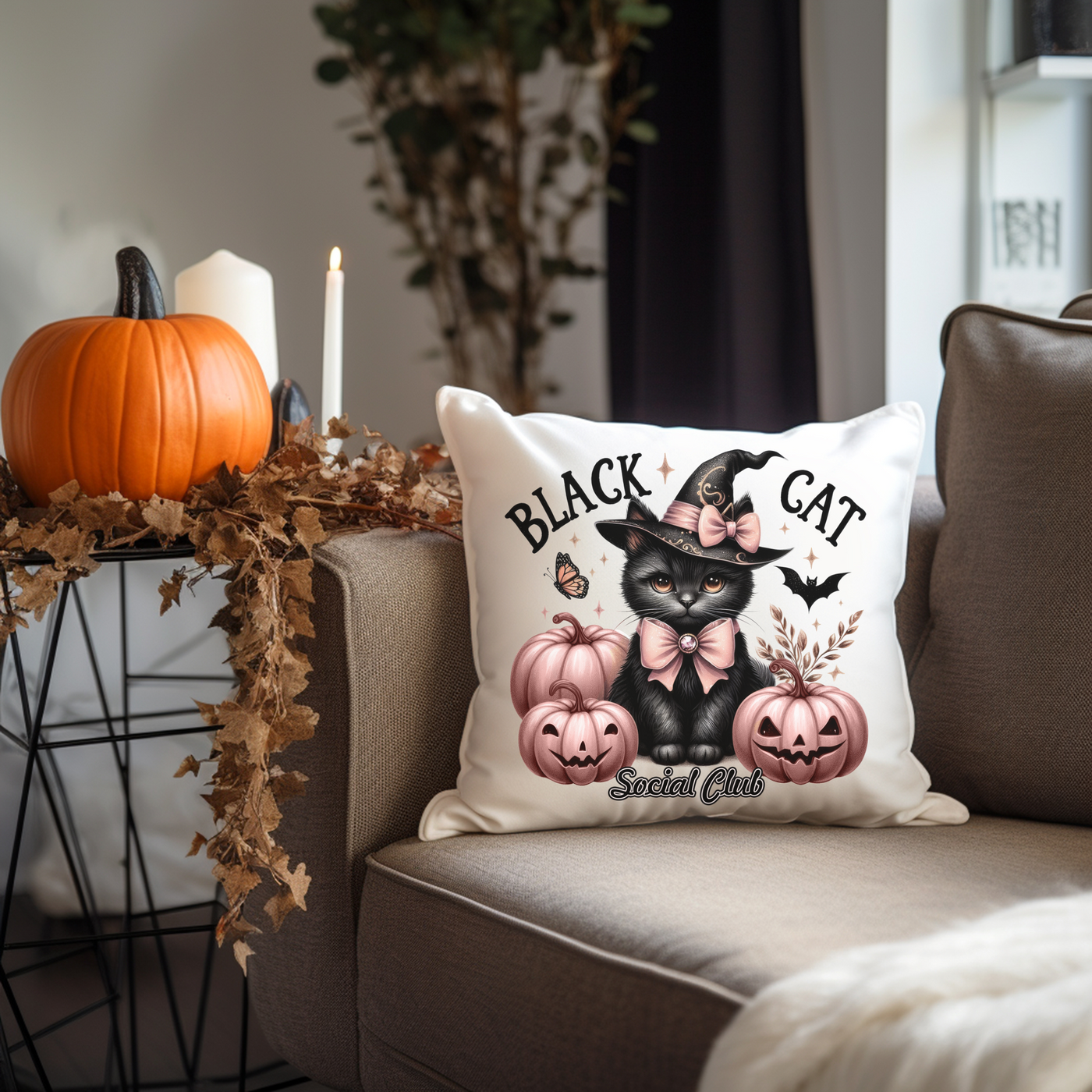 a black cat pillow sitting on top of a couch