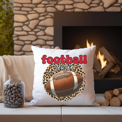 a football pillow sitting on top of a couch next to a fire place