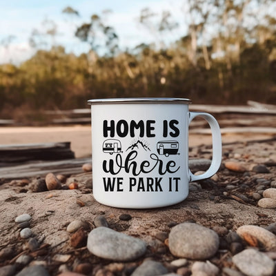 a camper mug sitting on the ground with the words home is where we park