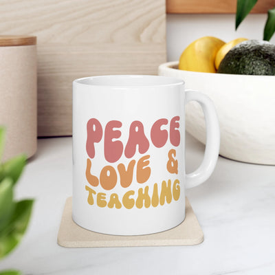 a coffee mug that says peace love and teaching