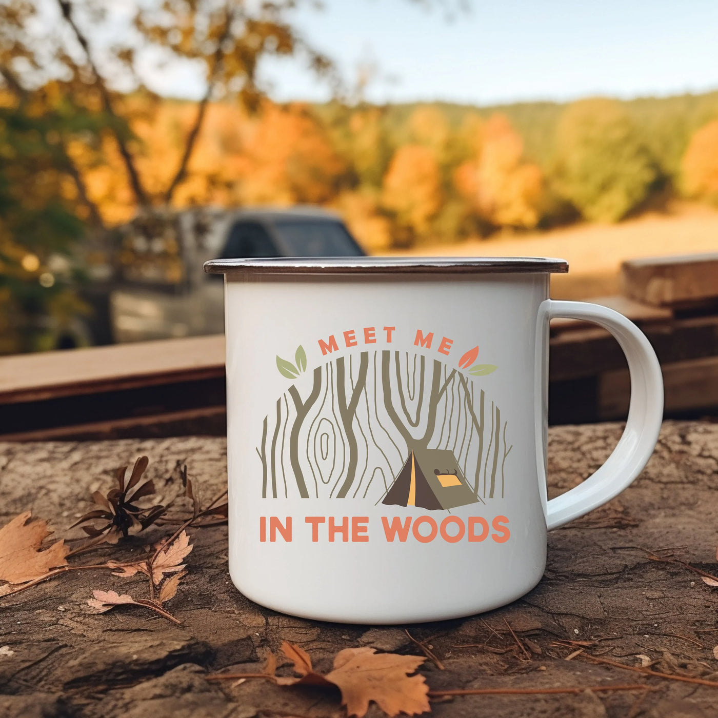 a camper mug sitting on the ground next to leaves