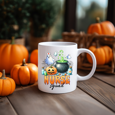 a white coffee mug with a pumpkin and ghost on it