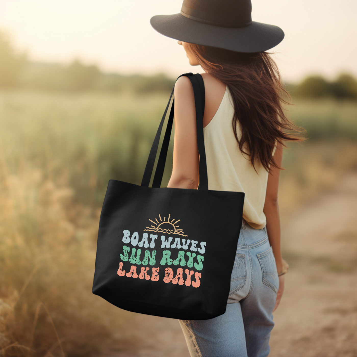 a woman carrying a black bag that says boat waves, sun rays, lake days