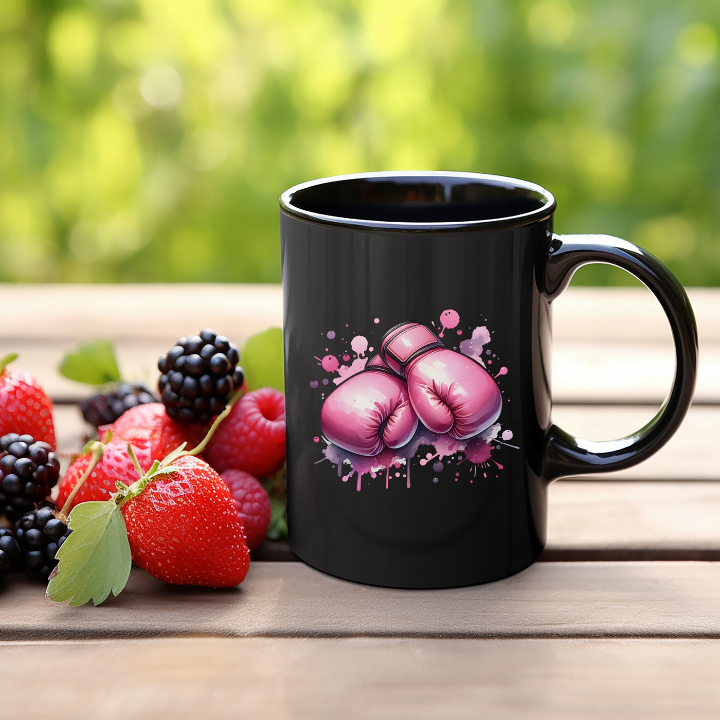 a black coffee mug with pink boxing gloves and berries