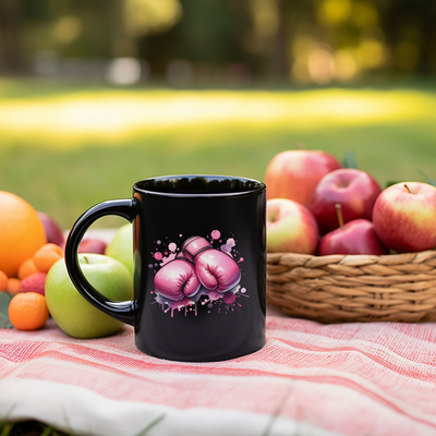 a black coffee mug sitting on top of a table next to a basket of fruit