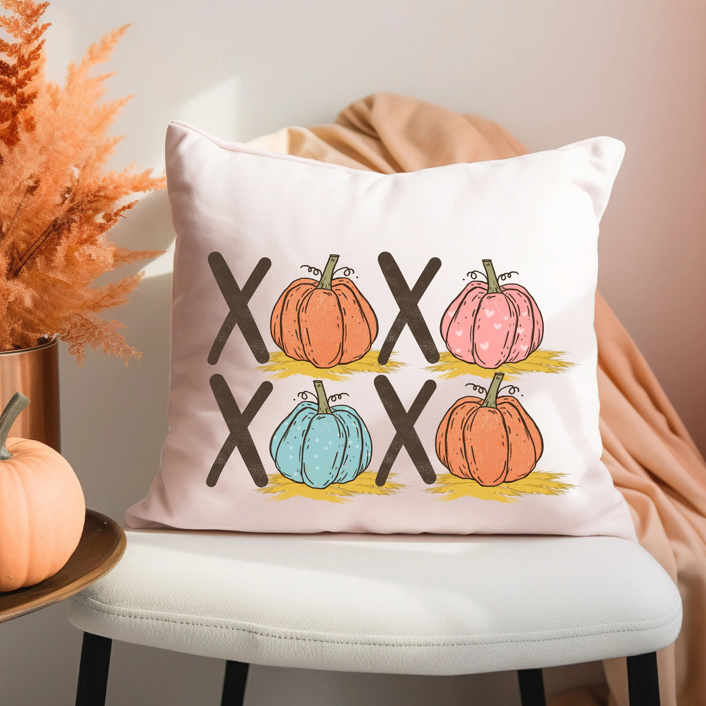 a white pillow with three pumpkins on it