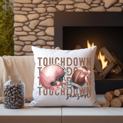 a football pillow sitting on top of a couch next to a fire place