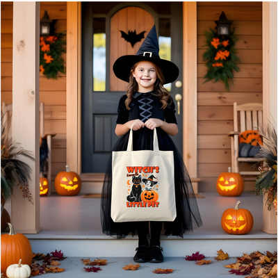 a little girl in a witch costume holding a trick or treat bag