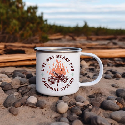 a campfire mug sitting on a rocky beach