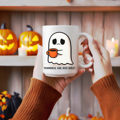 a person holding a coffee mug with a ghost on it