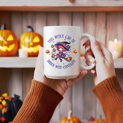 a woman holding a coffee mug with a witch on it