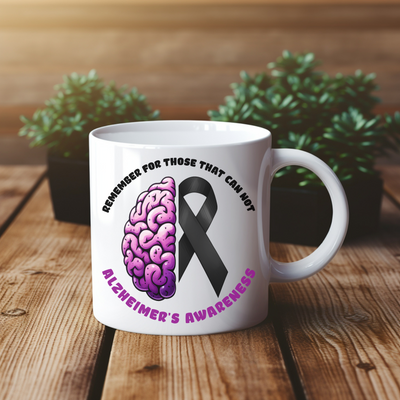 a white coffee mug with a pink ribbon and a brain on it