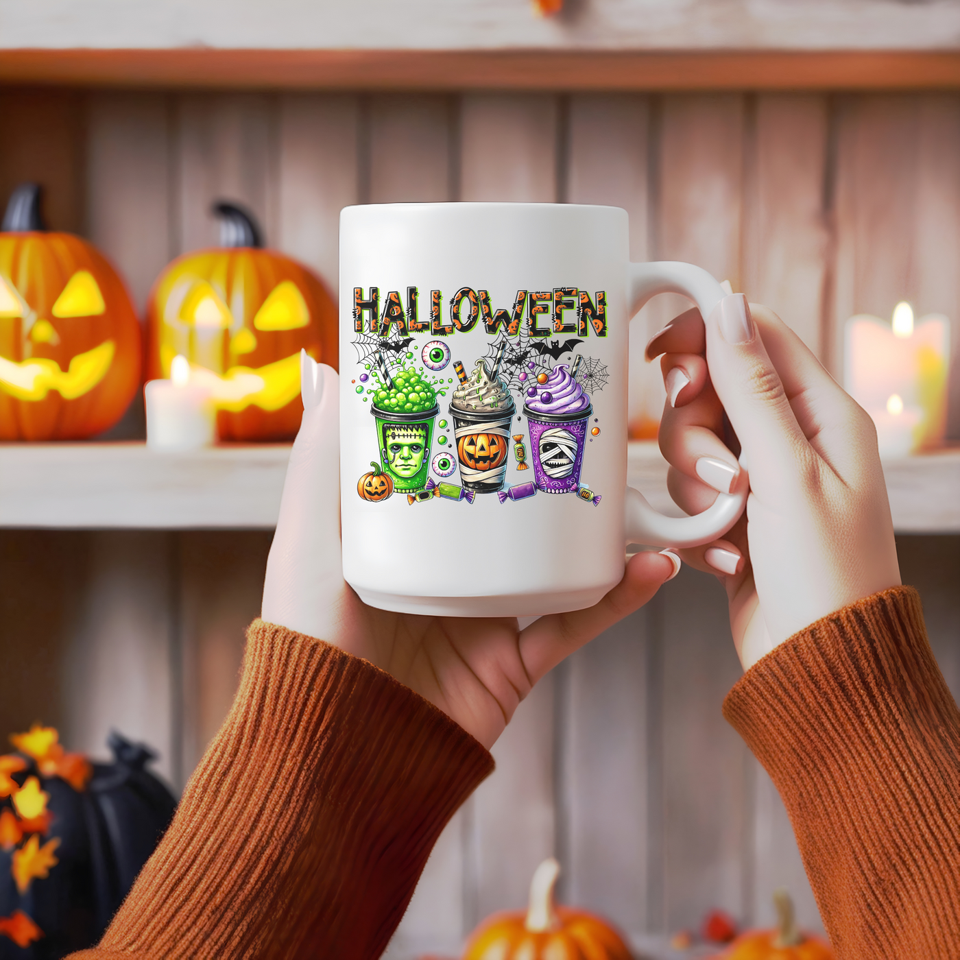 a person holding a coffee mug with a halloween scene on it