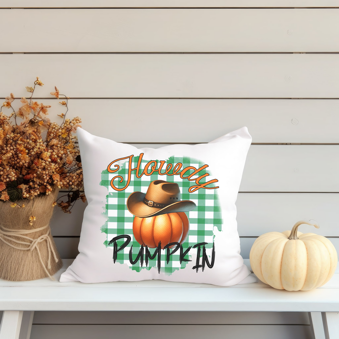 a pumpkin pillow sitting on top of a white bench