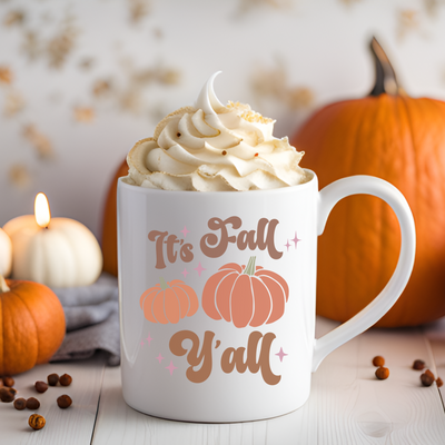 a cup of coffee with whipped cream and pumpkins around it