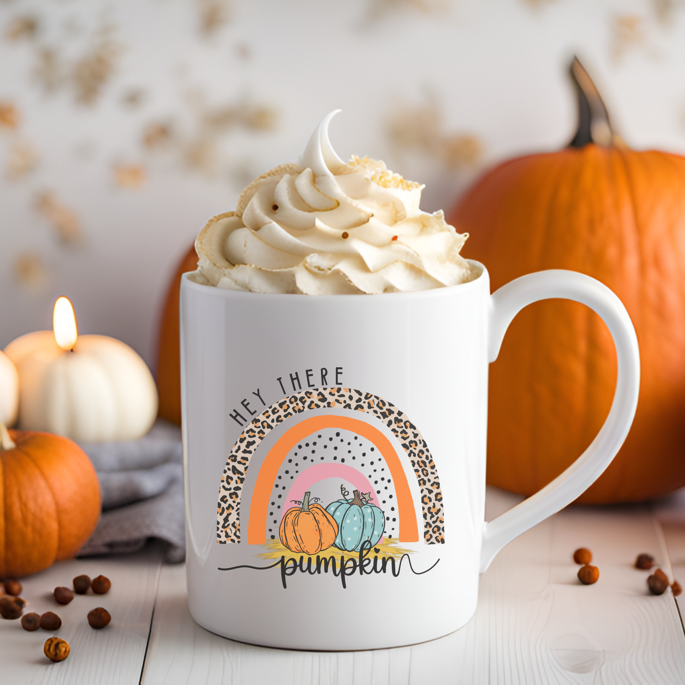 a cup of coffee with whipped cream and pumpkins in the background