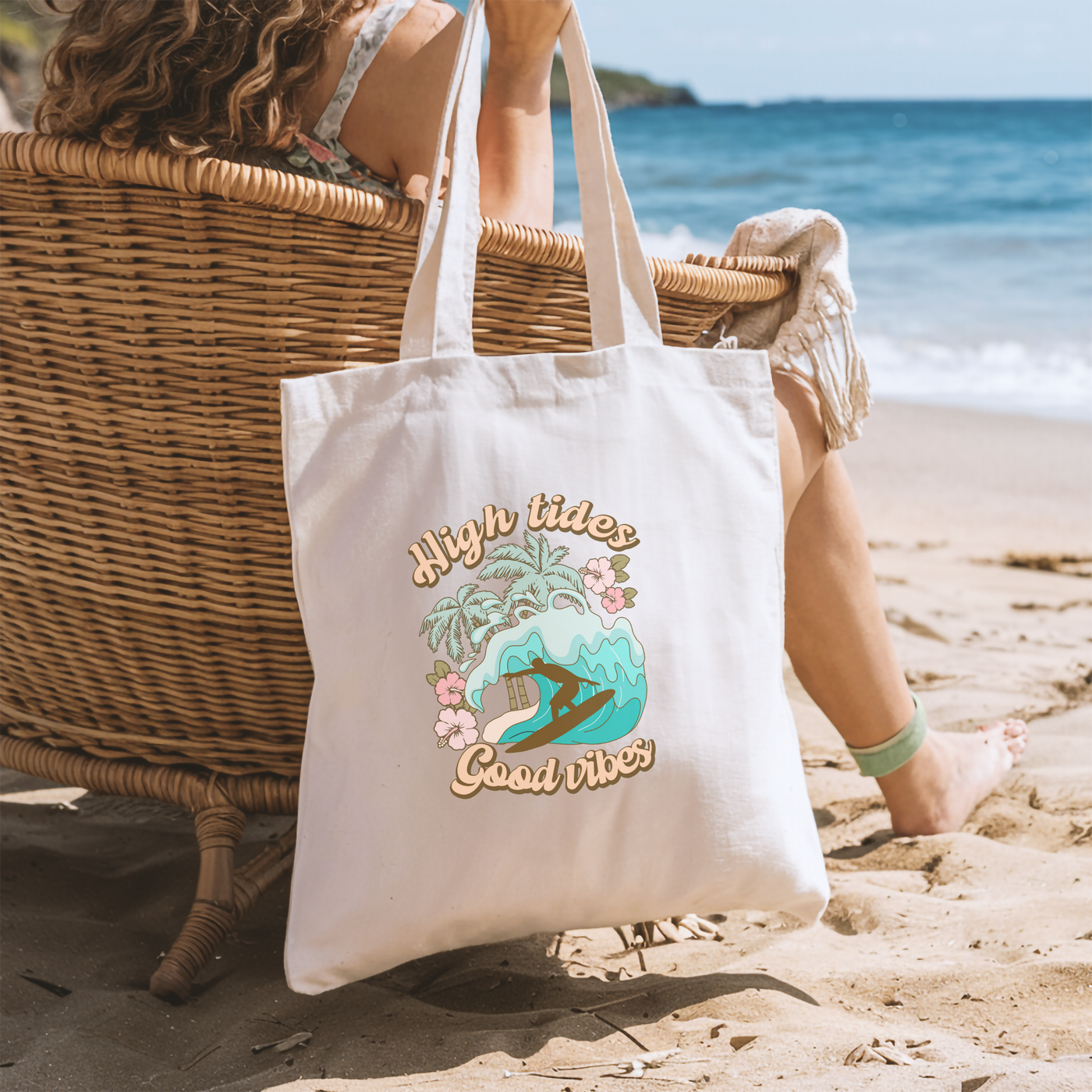 a woman sitting in a chair on the beach with a tote bag